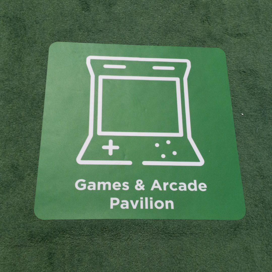 Photo of a green carpet and sticker that says "Games & Arcade Pavilion"