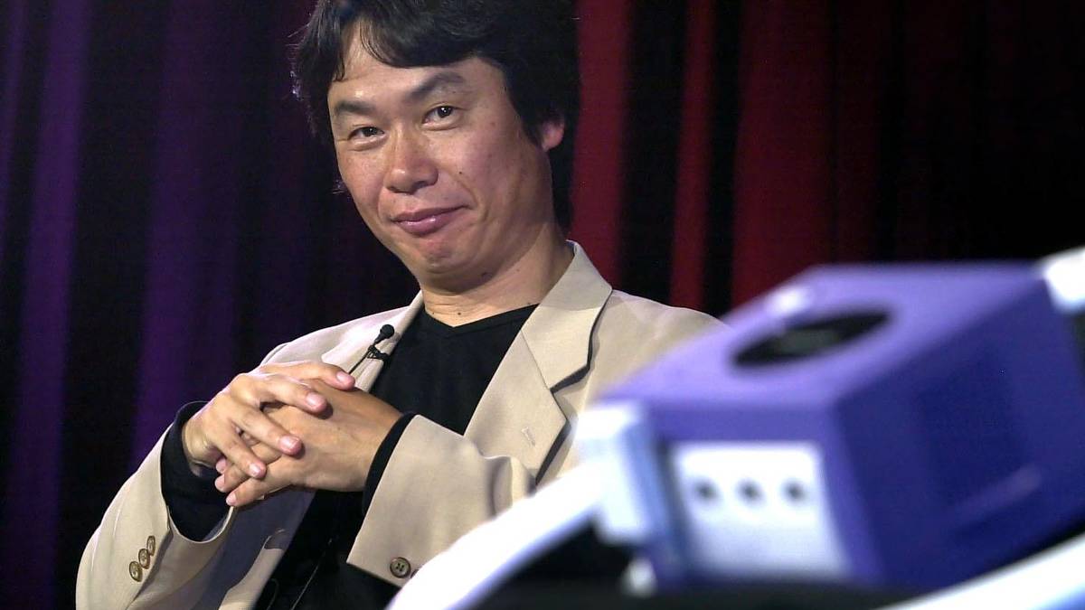 Shigeru Miyamoto looking at the Nintendo Gamecube, foreground, during the console’s reveal in May 2001