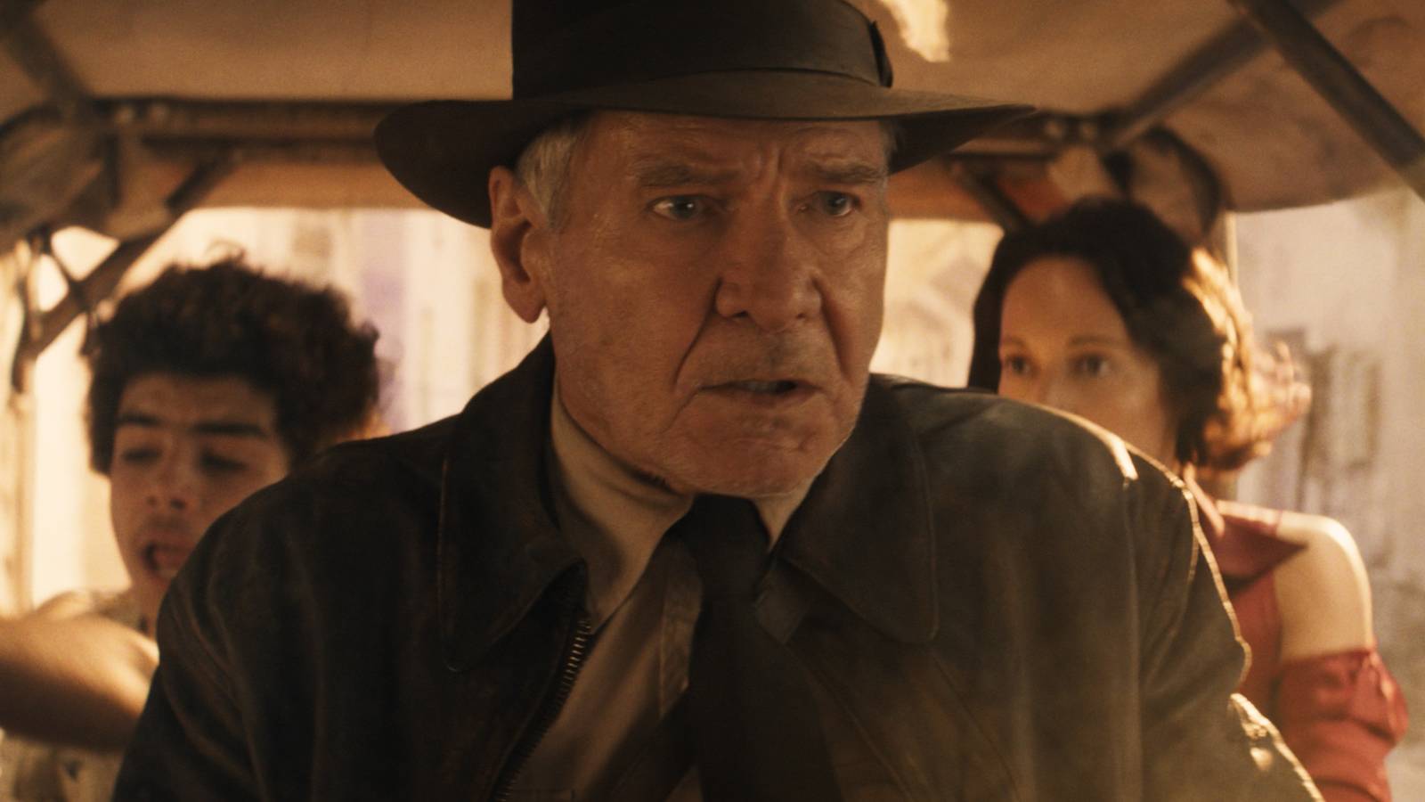 Indiana Jones looks panicked as he drives a cart with Helena and Teddy in the backseat in Indiana Jones and the Dial of Destiny
