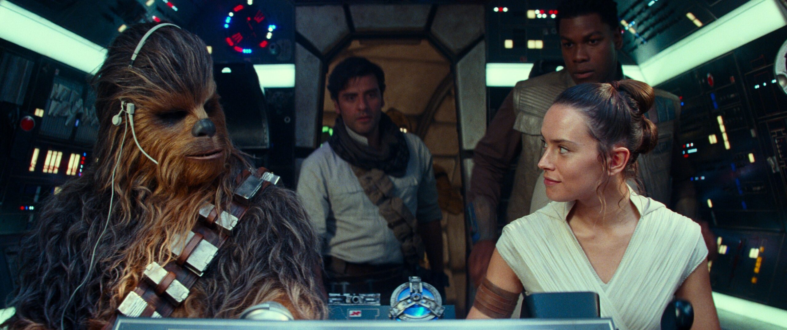Star Wars: The Rise of Skywalker characters Chewbacca, Poe, Rey, and Finn look at each other in the Millennium Falcon.