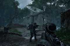 A player in PUBG: Black Budget approaching a building with a satellite dish in the jungle with two more players in front of them.
