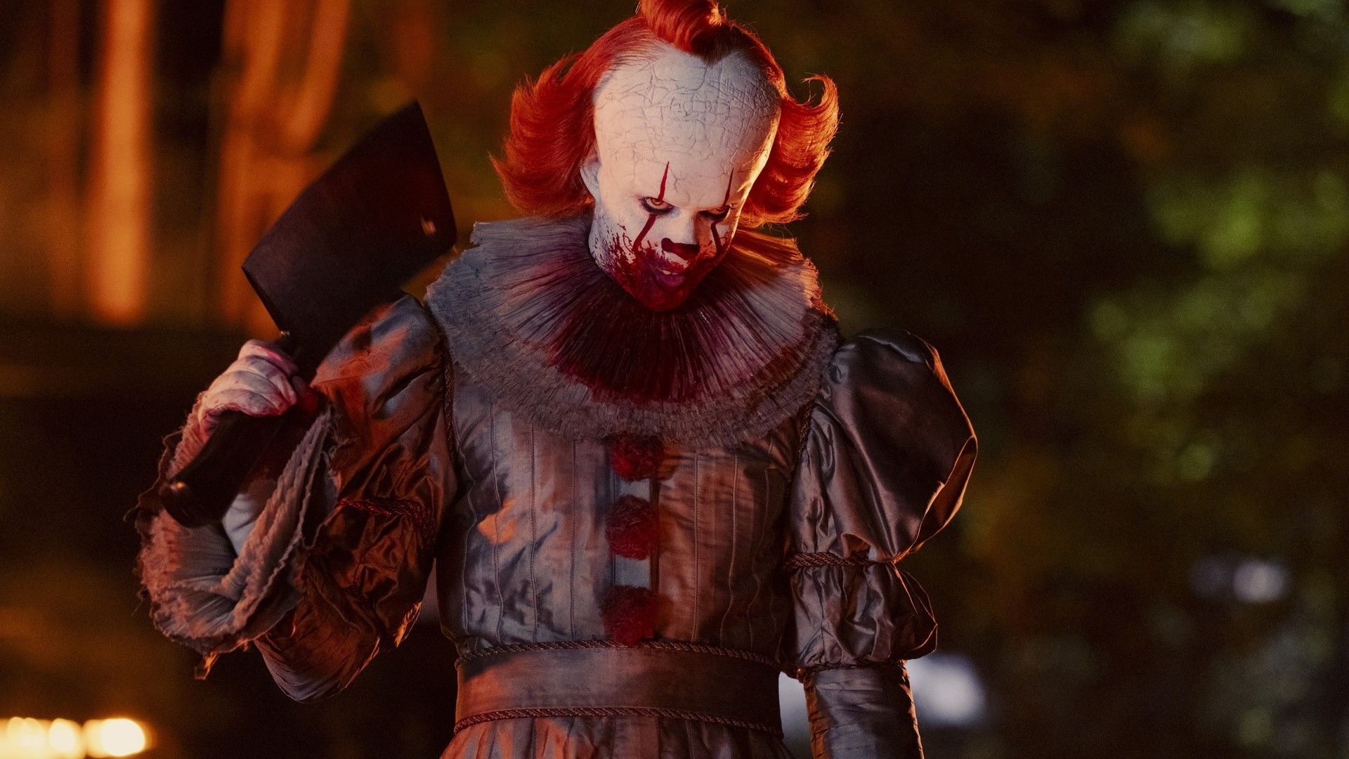 Pennywise outside the burning Black Spot holding a hatchet in It: Welcome to Derry