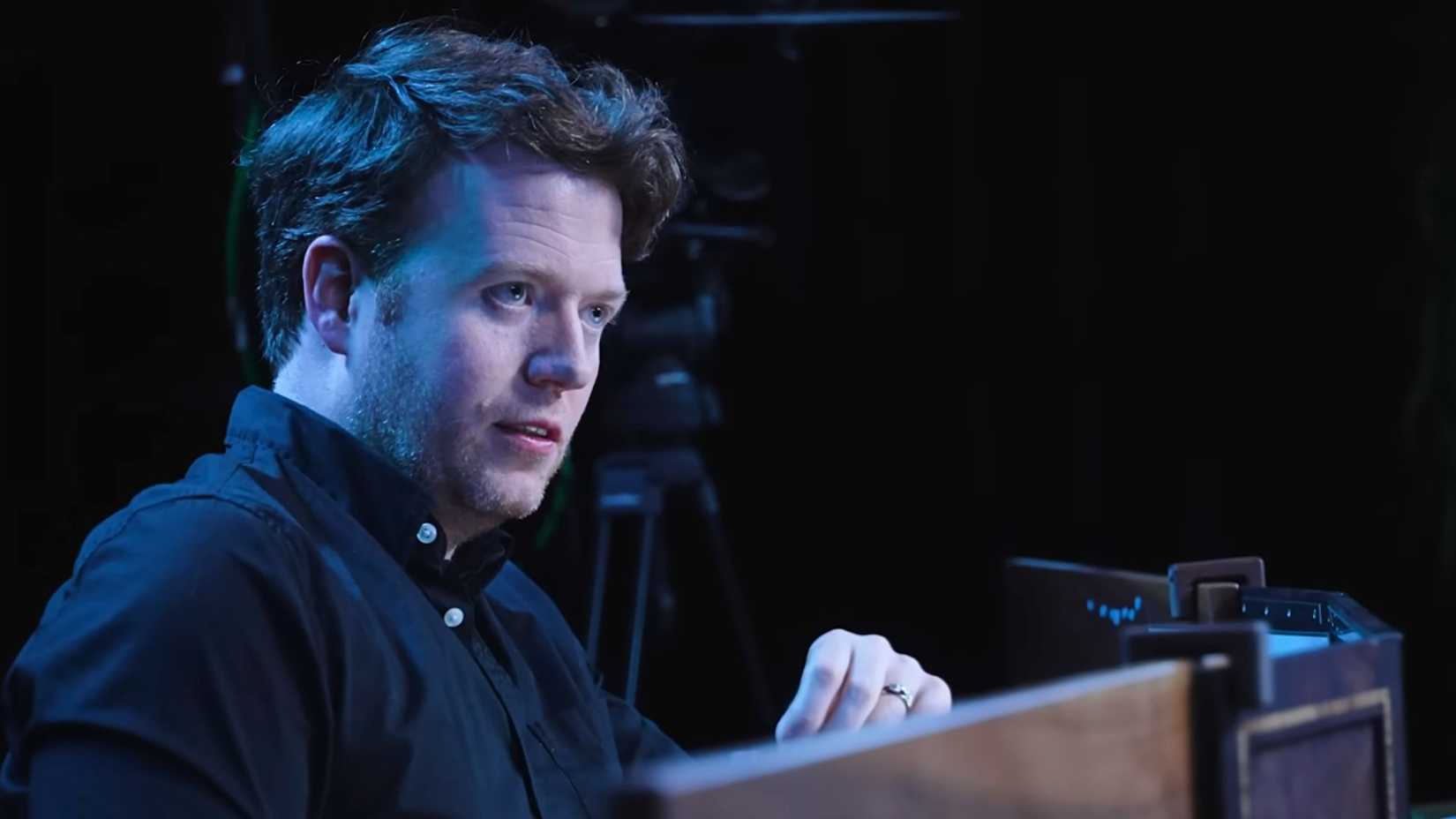 critical role campaign 4. brennan narrates a scene, covered in blue and white lighting