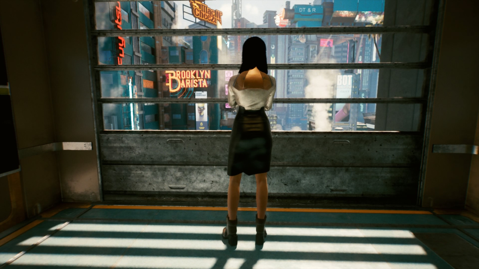 V stands in an elevator with her back facing the camera, alone. She's in a black pencil skirt and white blouse.