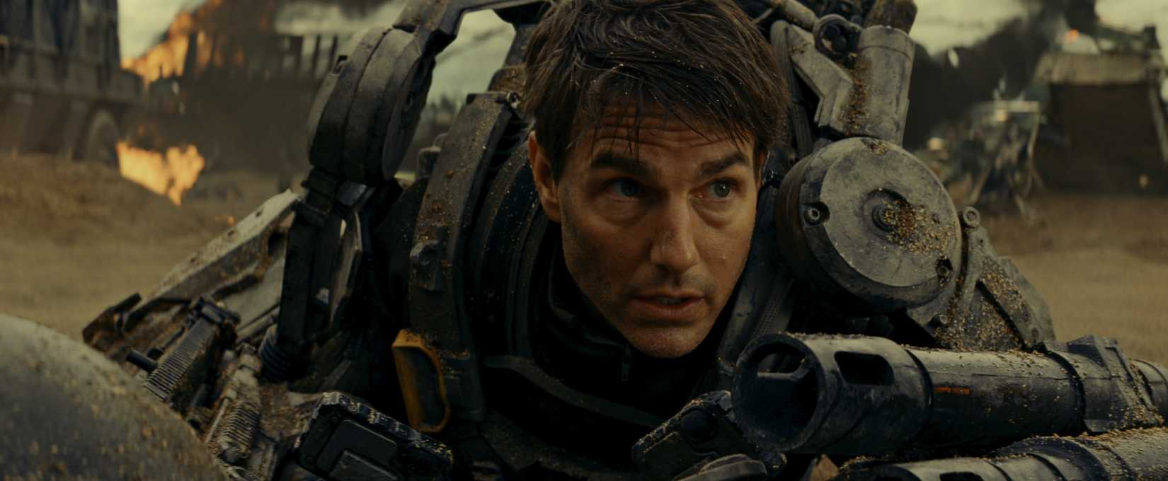 Tom Cruise’s military officer in an exosuit falls to the ground catching his breath during the heat of alien war in Edge of Tomorrow