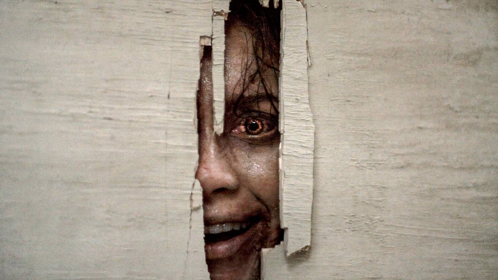 A deadite peeking through the door in Evil Dead Burn
