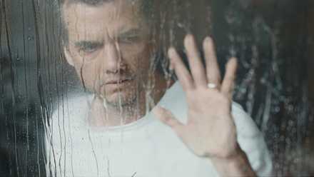The Last House- Wagner Moura puts his hand on a rainy window