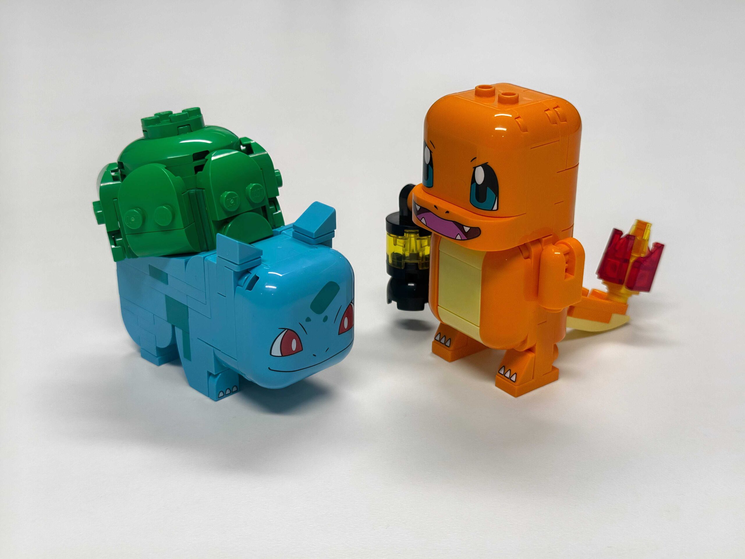 A Lego Bulbasaur and Charmander stand on a table.