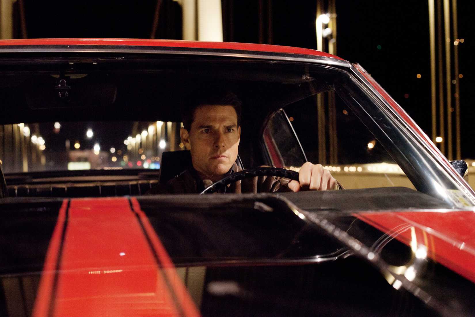 Tom Cruise looks determined behind the wheel of a cool muscle car