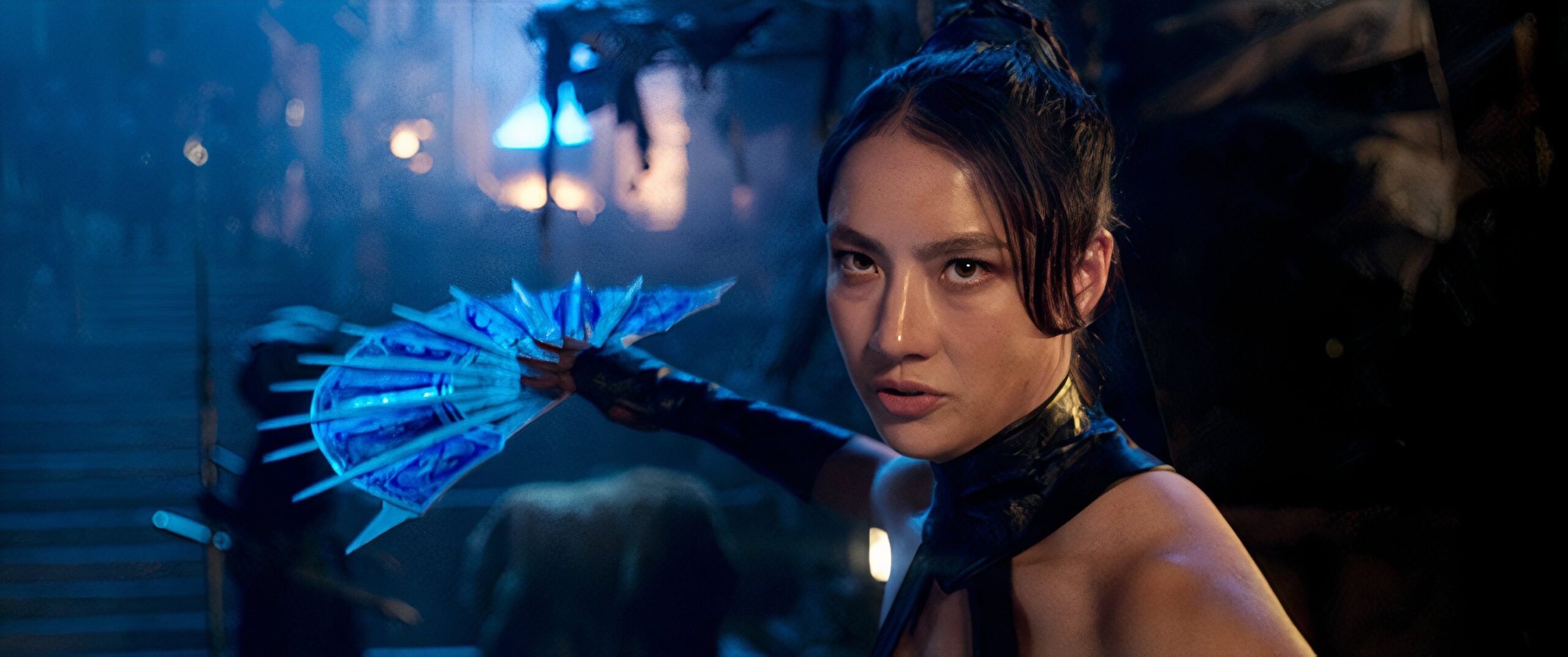 Kitana, a young woman with her hair in a topknot, wields a bladed metal fan as a weapon in Mortal Kombat 2