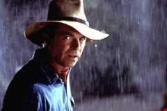 Sam Neill as Dr Alan Grant standing in the rain with his signature hat