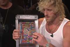 Logan Paul holds a perfectly graded CoroCoro magazine during a Pokemon livestream.