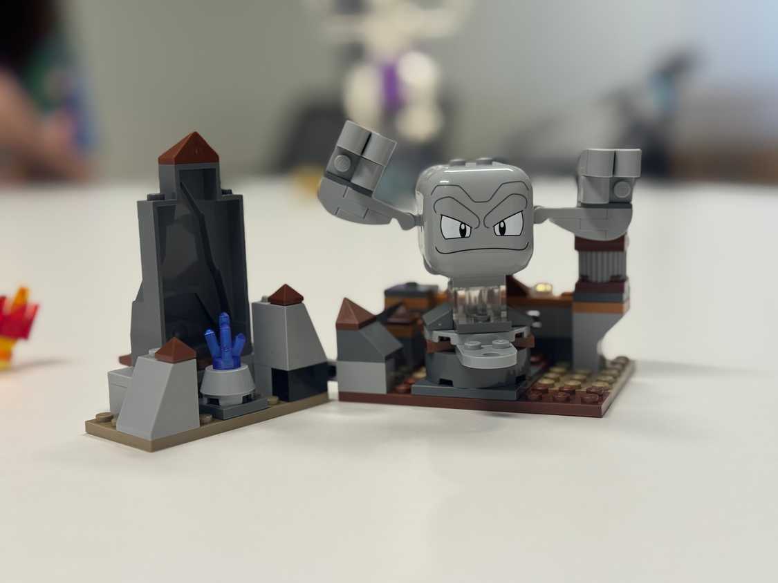 A Lego Geodude sits on a table.
