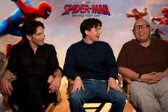 The three men sit in a row of chairs