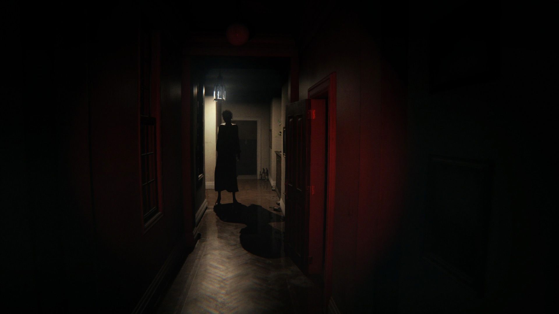 P.T.’s ghost, Lisa, stands in a dark hallway