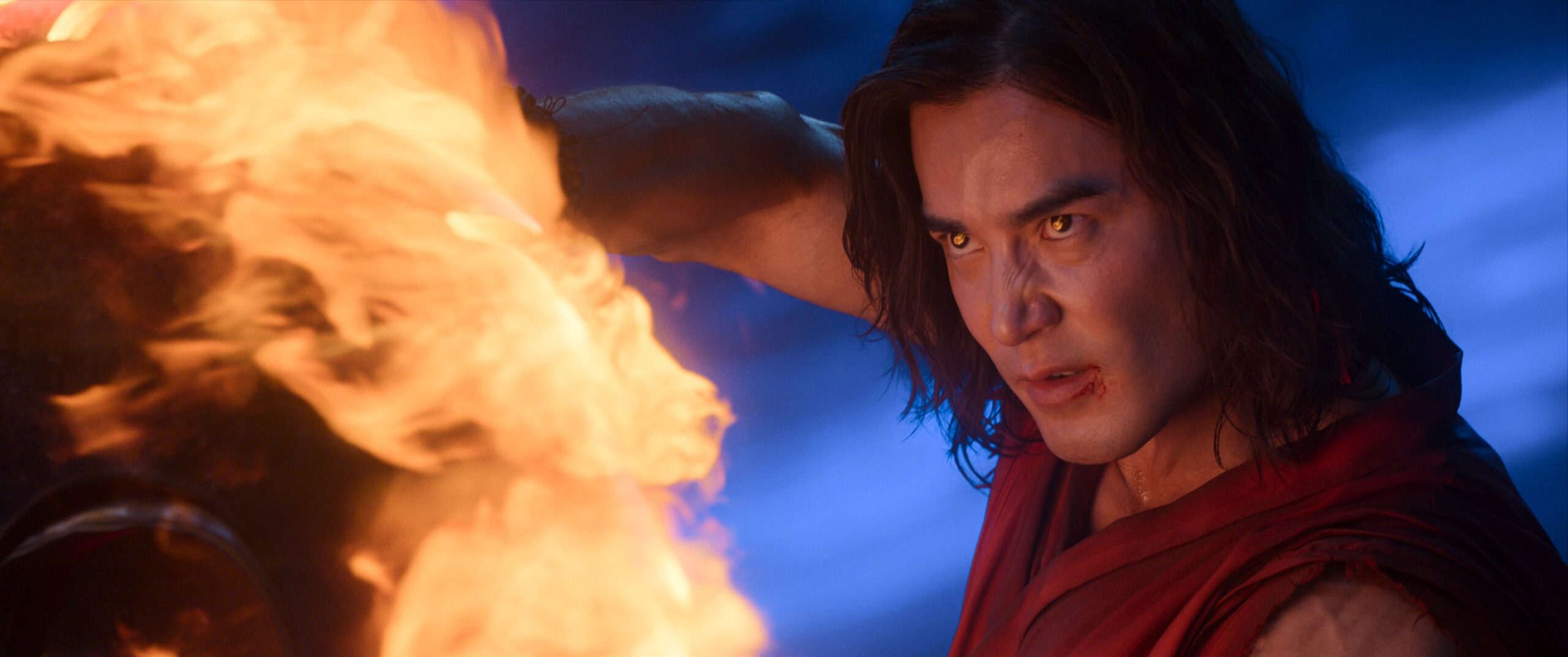 Liu Kang (Ludi Lin, a long-haired man in a red robe, looks ferocious as he blasts fire in Mortal Kombat 2