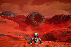 Rustbound trailer screenshot showing a white robot rising out of red sand against an ominous backdrop