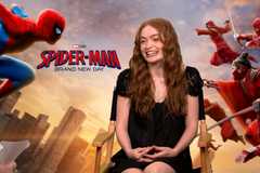 Sadie Sink smiles against a Spider-Man backdrop
