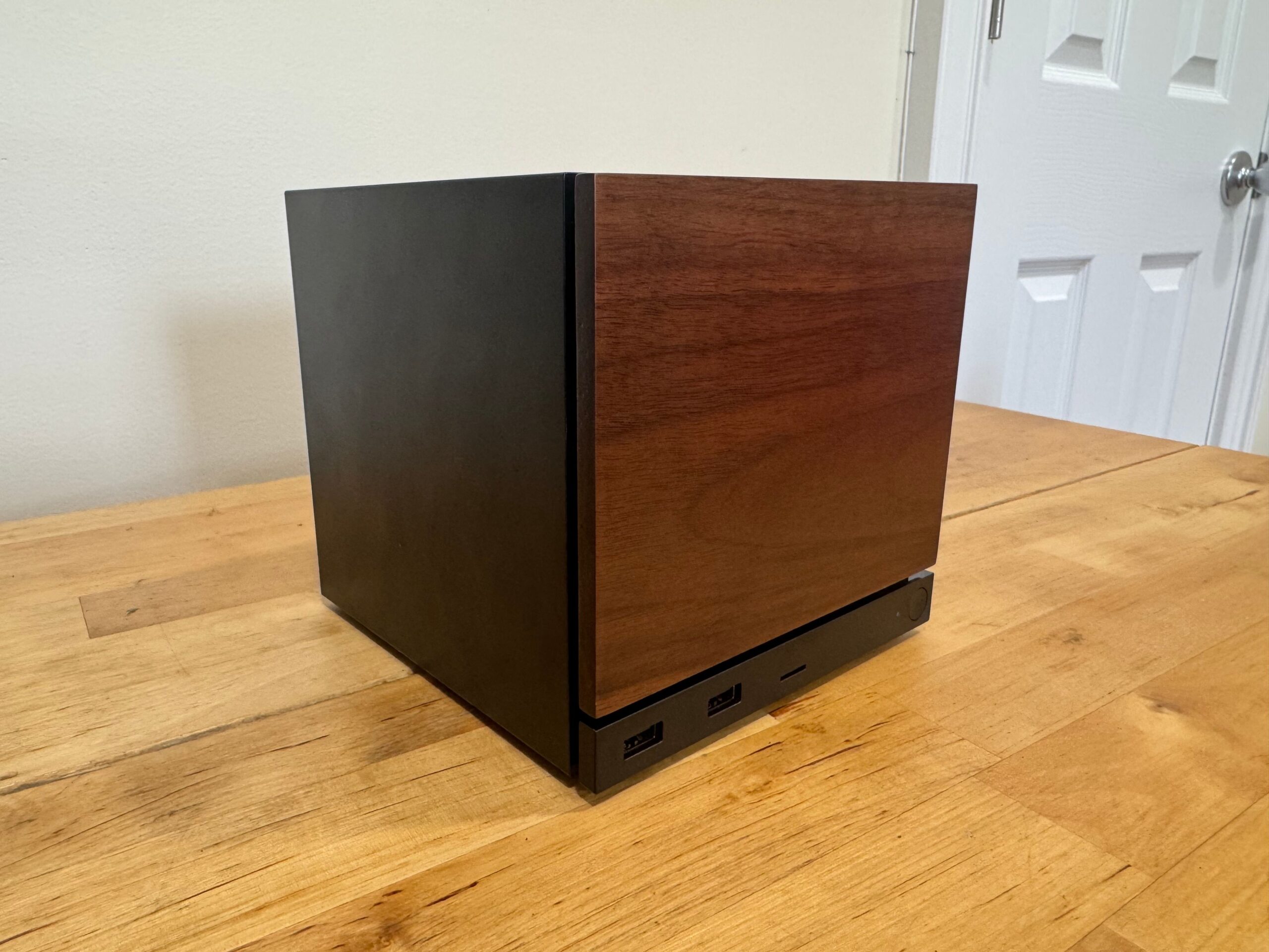 A Steam Machine with a wooden faceplate sits on a table.
