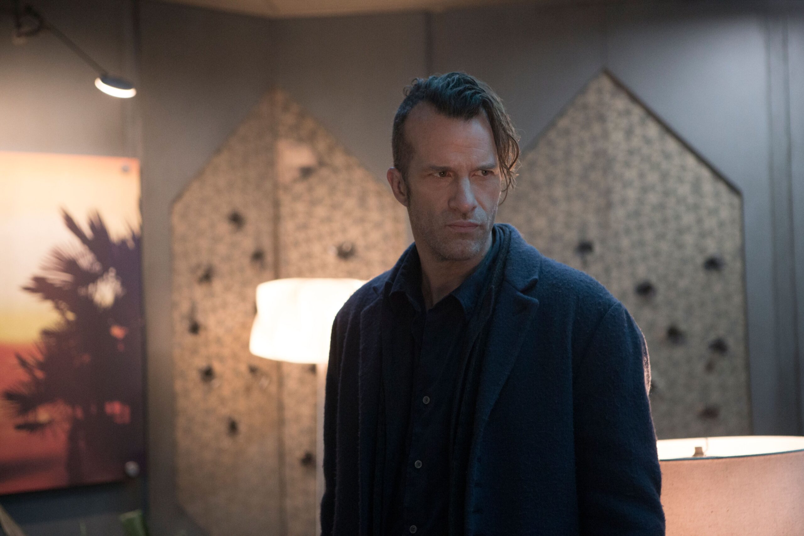 Joe Miller (Thomas Jane), a narrow, glowering man in all black with one side of his head shaved, in The Expanse