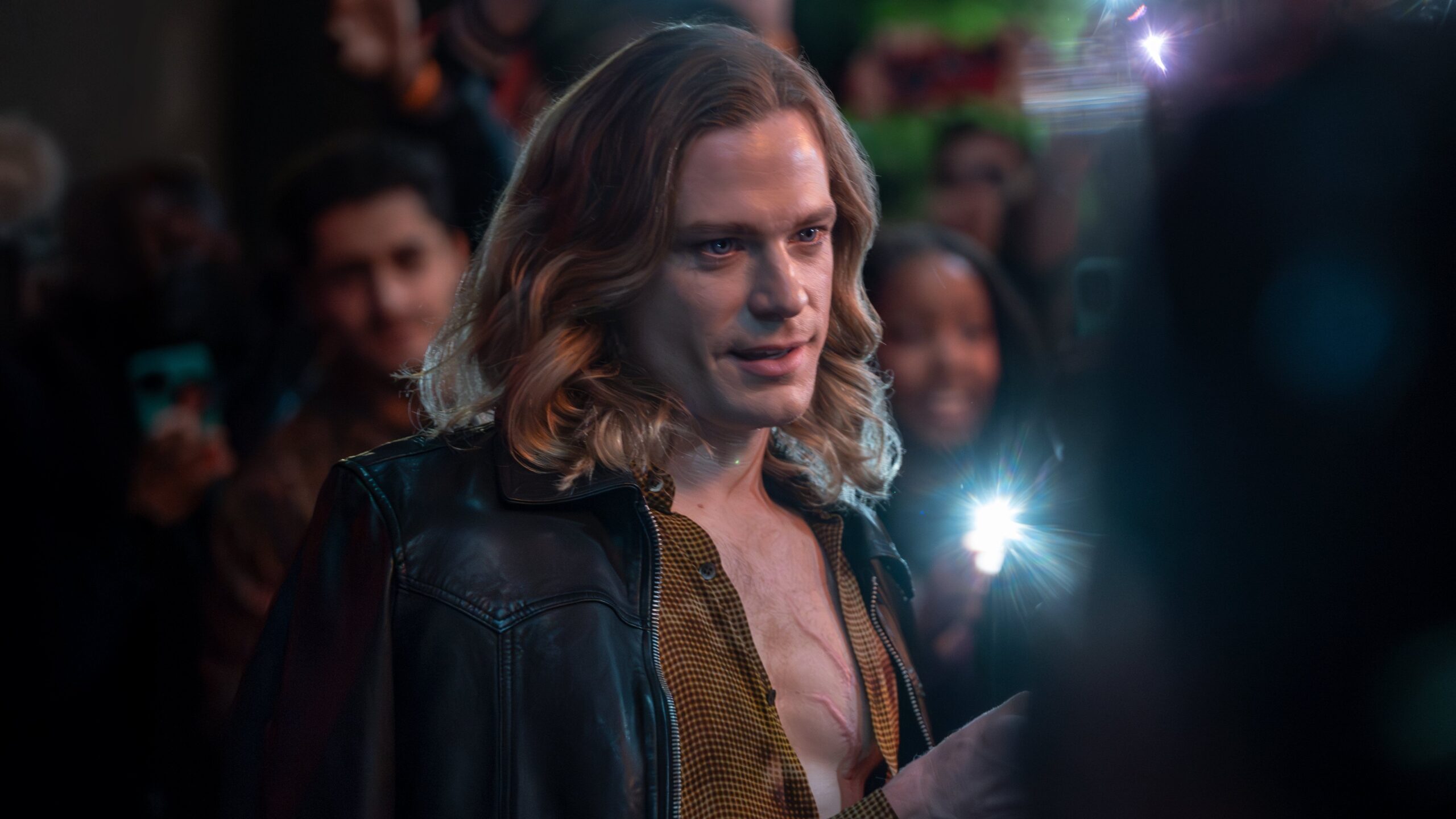 Lestat (Sam Reid) stands in front of a crowd taking pictures of him in The Vampire Lestat