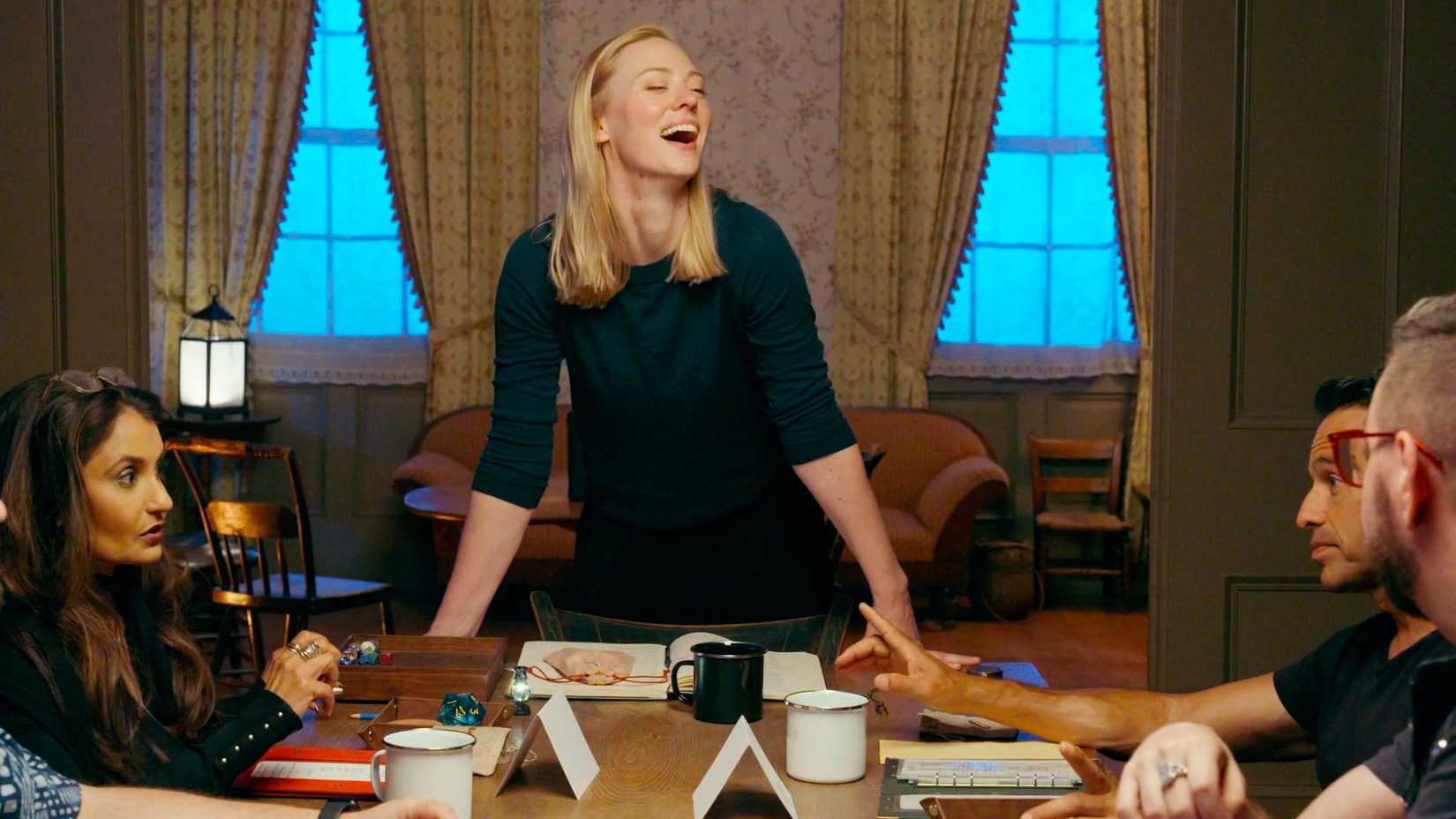 Deborah Ann Woll stands over a table as the Dungeon Master of Tales From Woodcreek