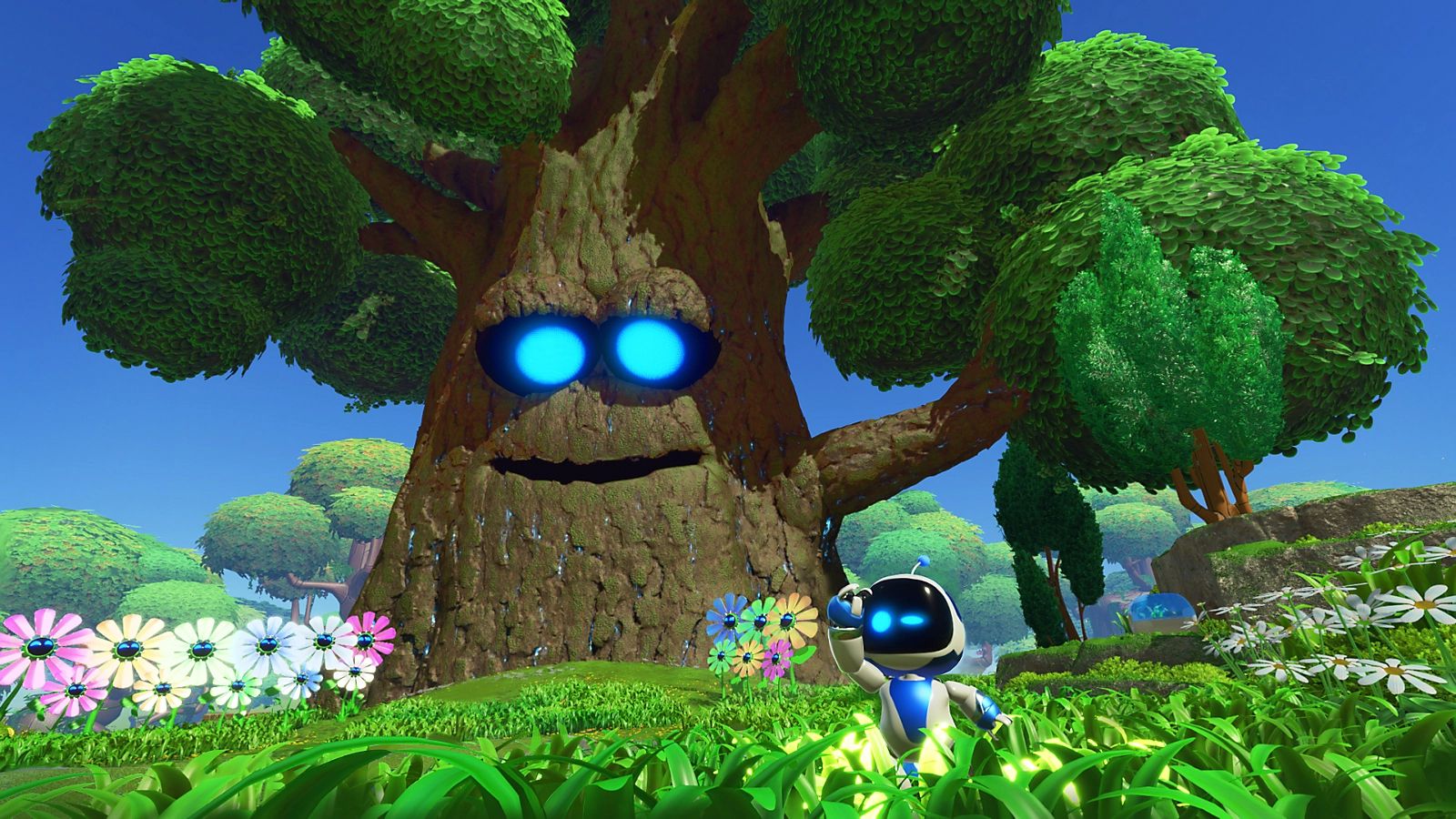 A screenshot from Astro Bot, featuring the titular hero standing in a grassy field with a tree with glowing blue eyes behind him