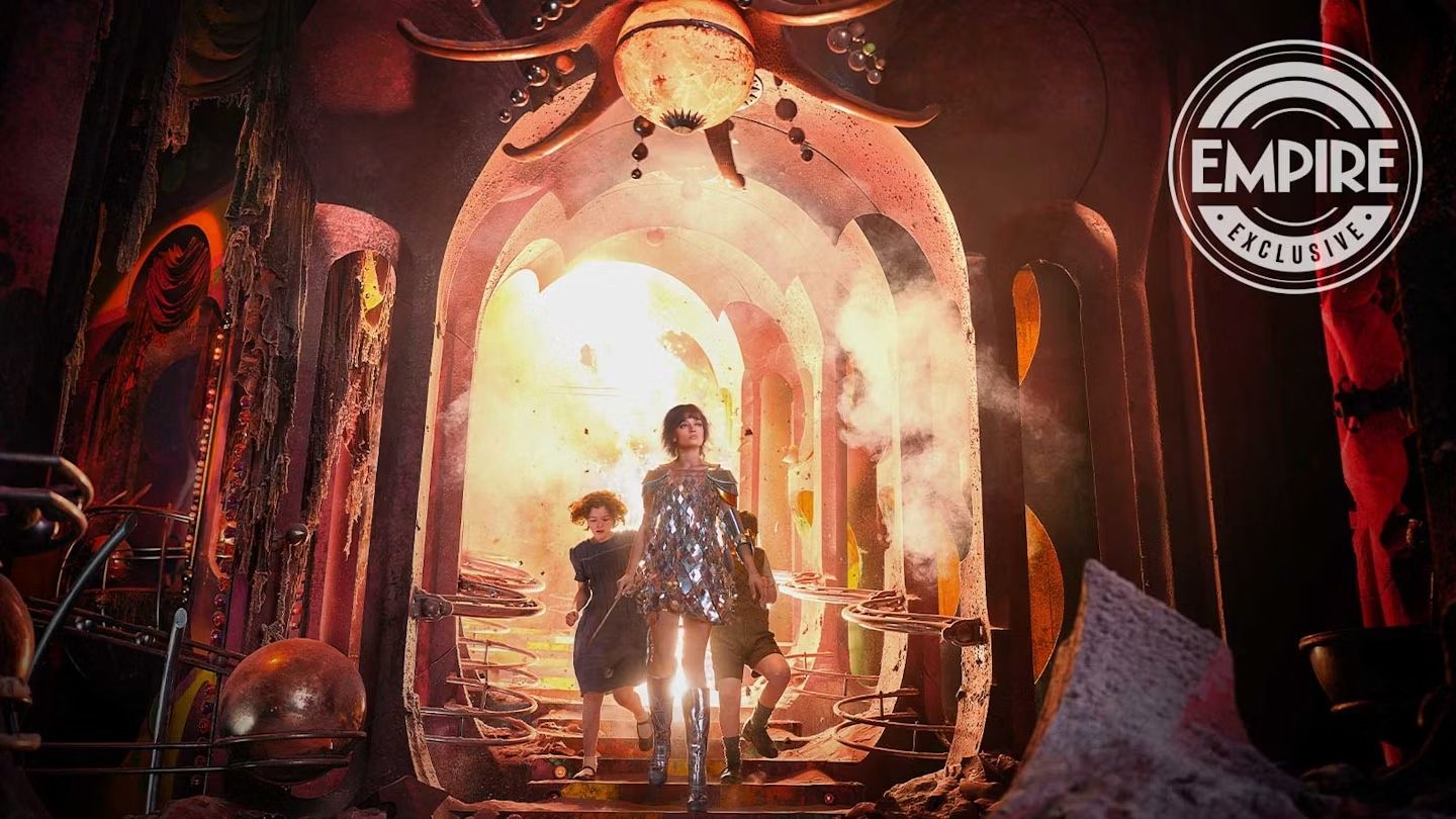 A woman in a glittery dress with two children walking away from an explosion.
