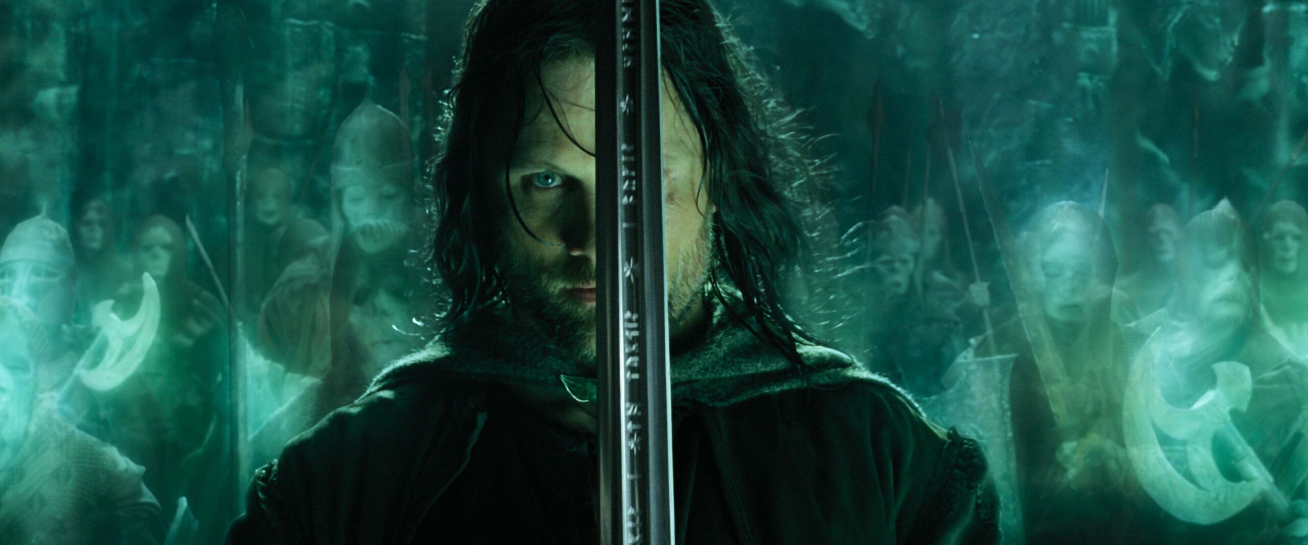 Aragorn holds his sword aloft with the spirits of warriors behind him in a still from The Lord of the Rings: Return of the King