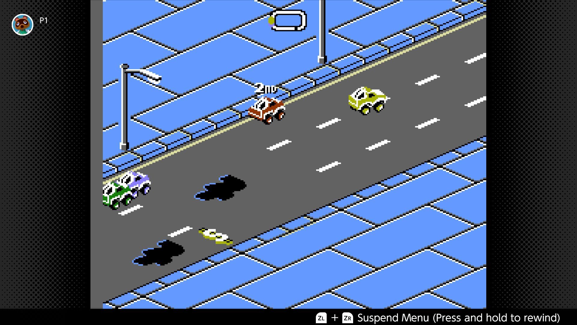 RC Pro-Am 2 screenshot - four vehicles dodge oil slicks on a straight stretch in the city environment