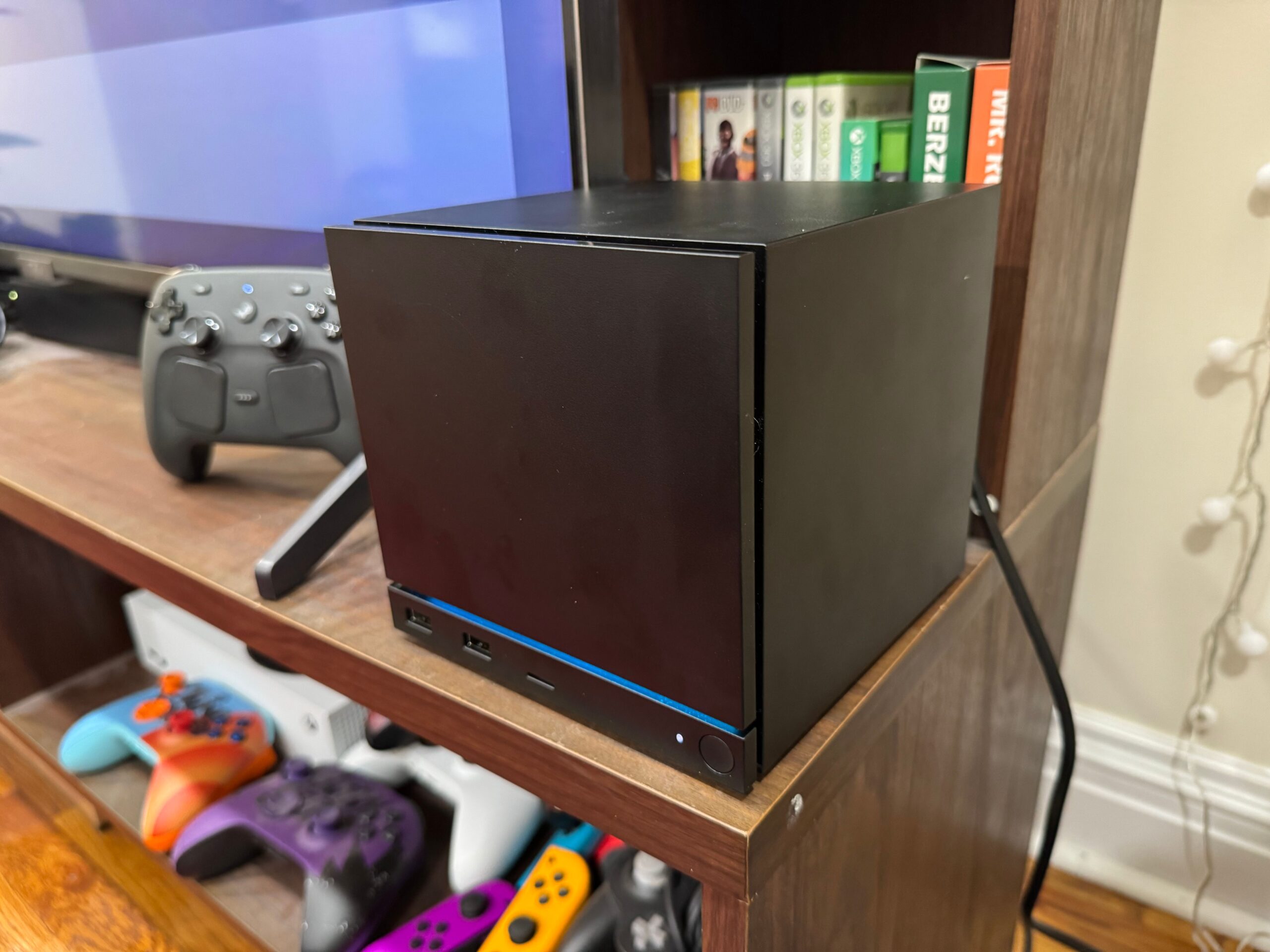 A Steam Machine sits on an entertainment center.