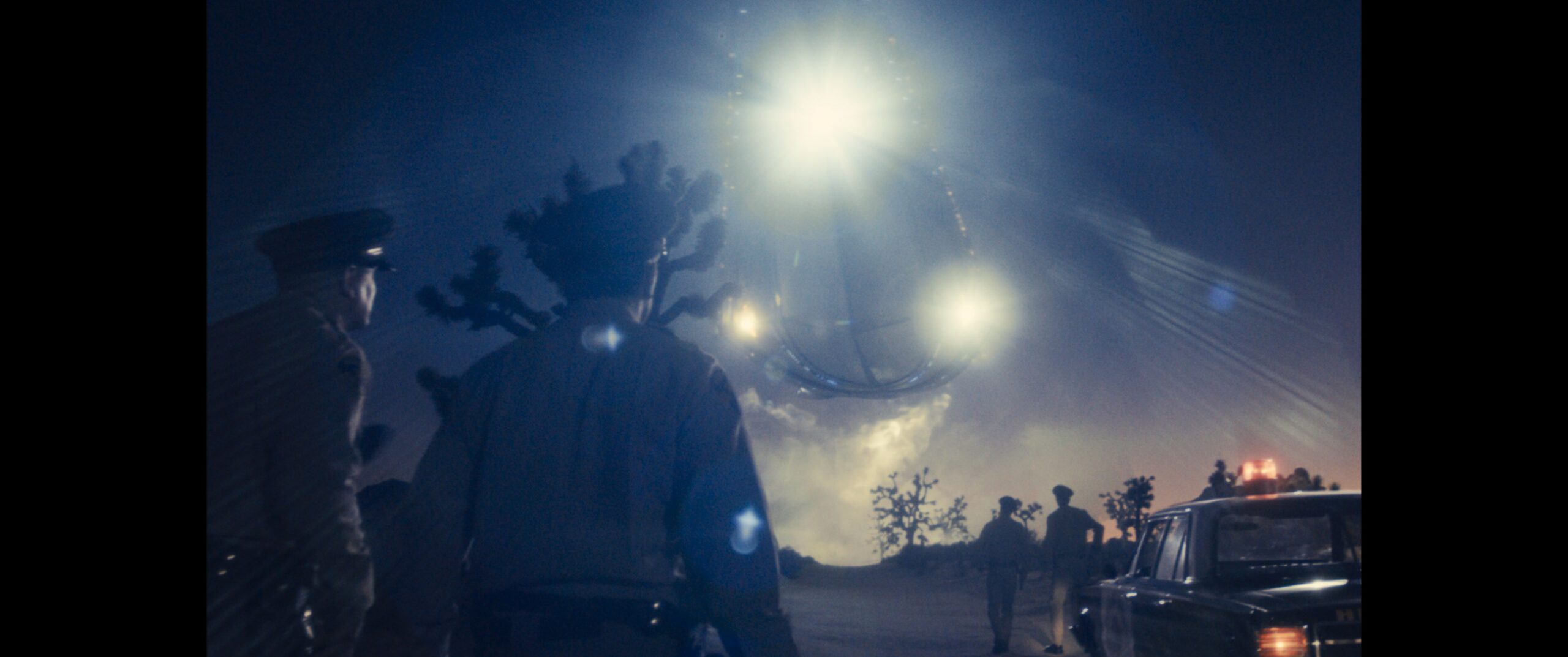 Disclosure Day - an unidentified flying object in the sky as police look on