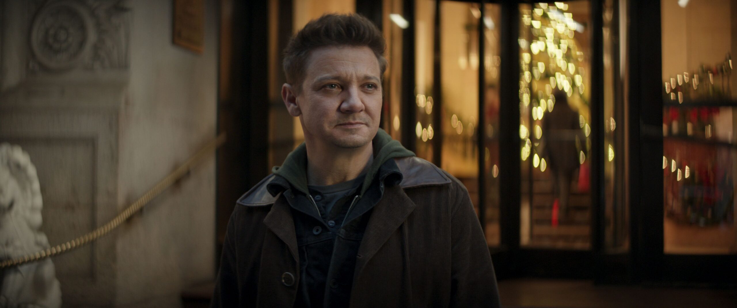Clint Barton (Jeremy Renner) standing outside an expensive Manhattan hotel in Hawkeye.