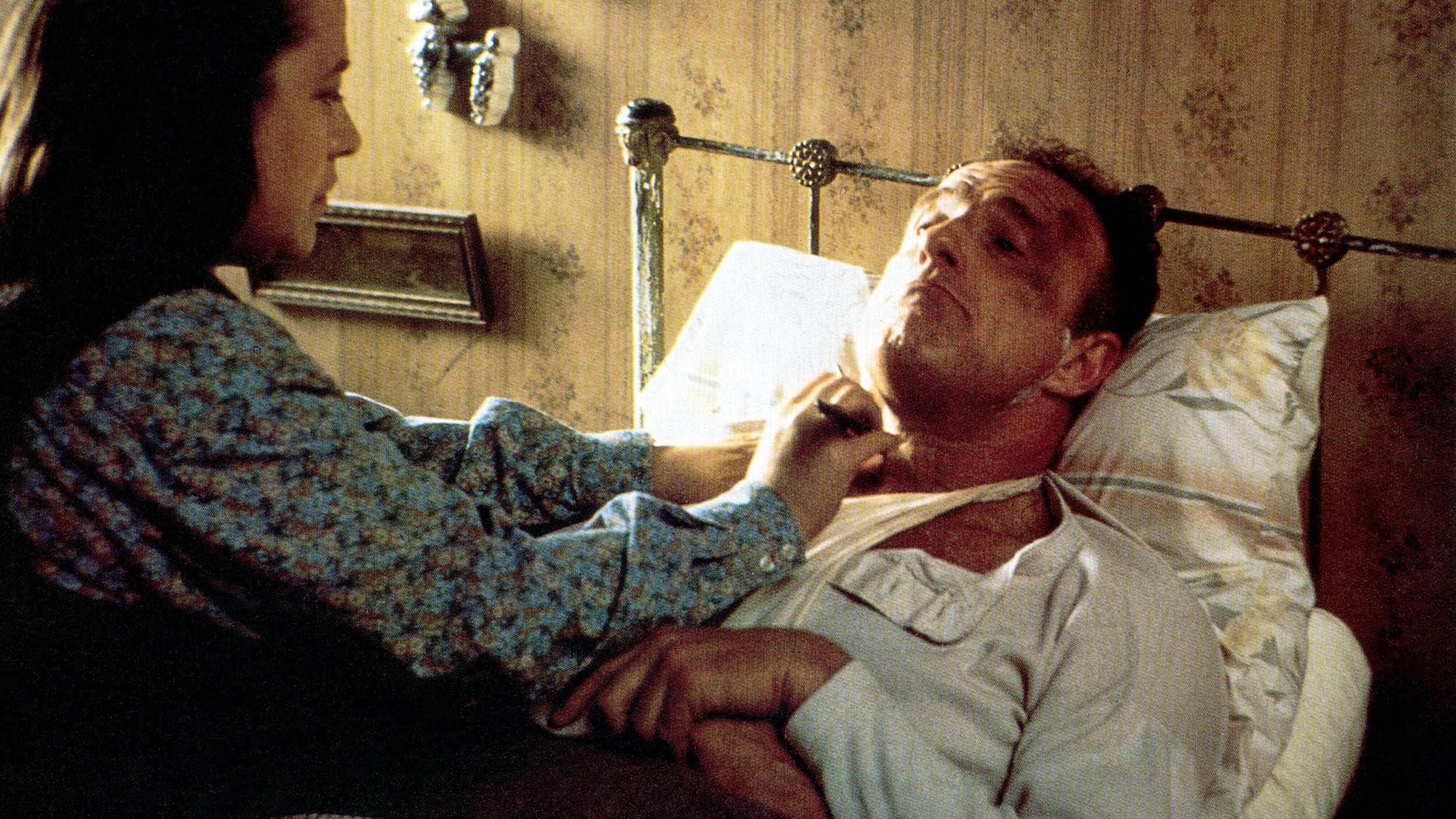 Annie Wilkes shaves a bruised, bandaged, bedridden Paul Sheldon in Misery.