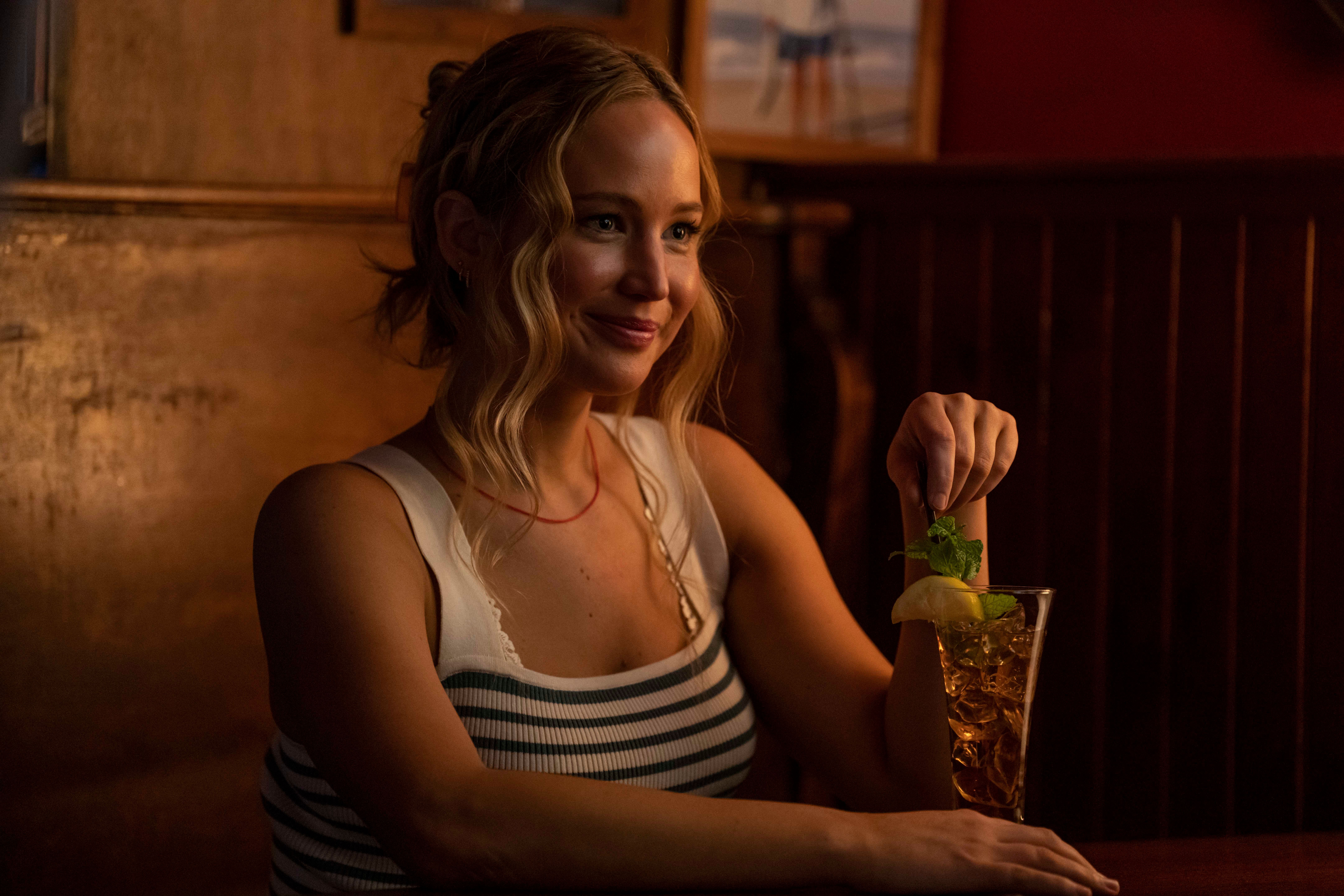 Jennifer Lawrence sits in a tank top at a bar booth with a Long Island Iced Tea in the movie No Hard Feelings.