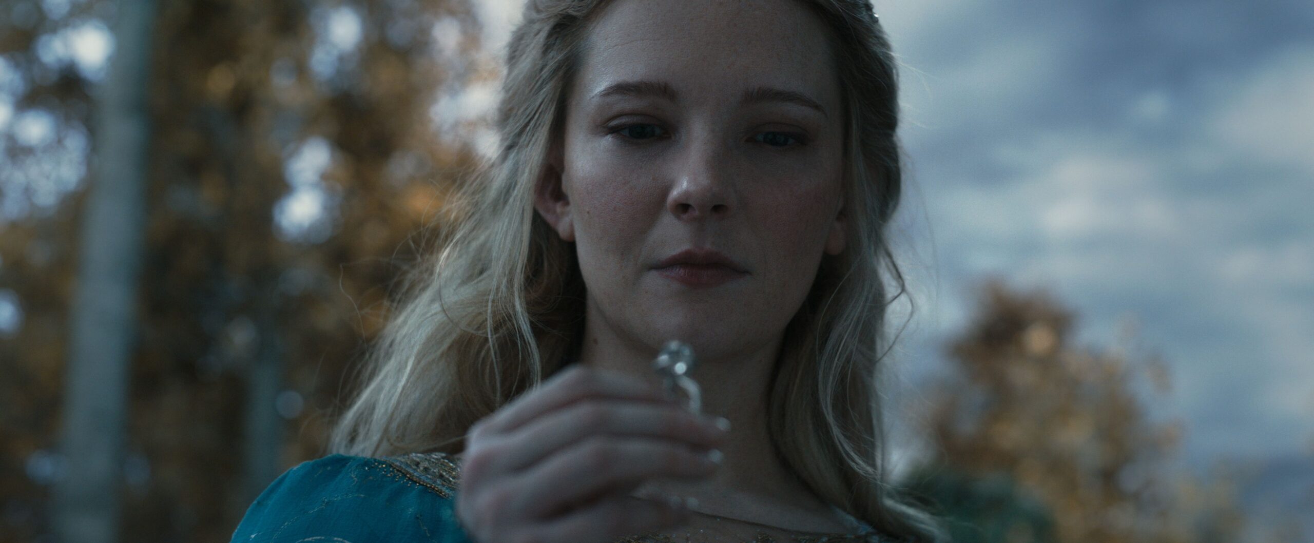 Galadriel holds up one of the elven rings of power and looks at it, in The Lord of the Rings: The Rings of Power.