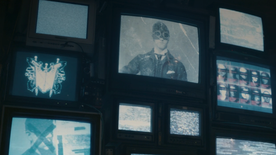 A bank of TVs shows information on Paladin in VisionQuest