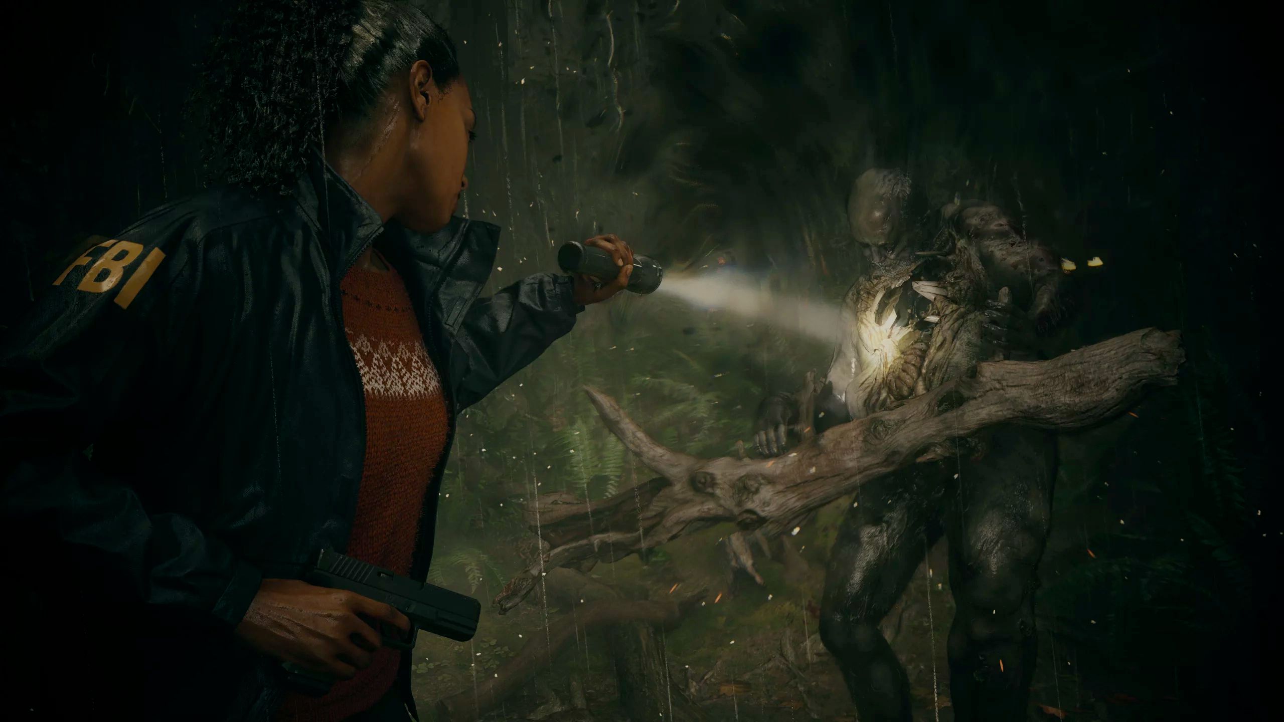 FBI agent Saga Anderson aims her flashlight at a monster in a forest setting in Alan Wake 2