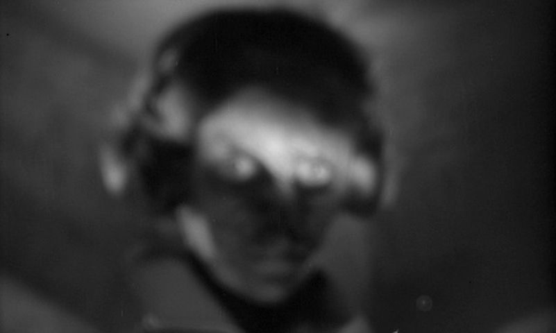 A blurry image of a woman's disfigured face