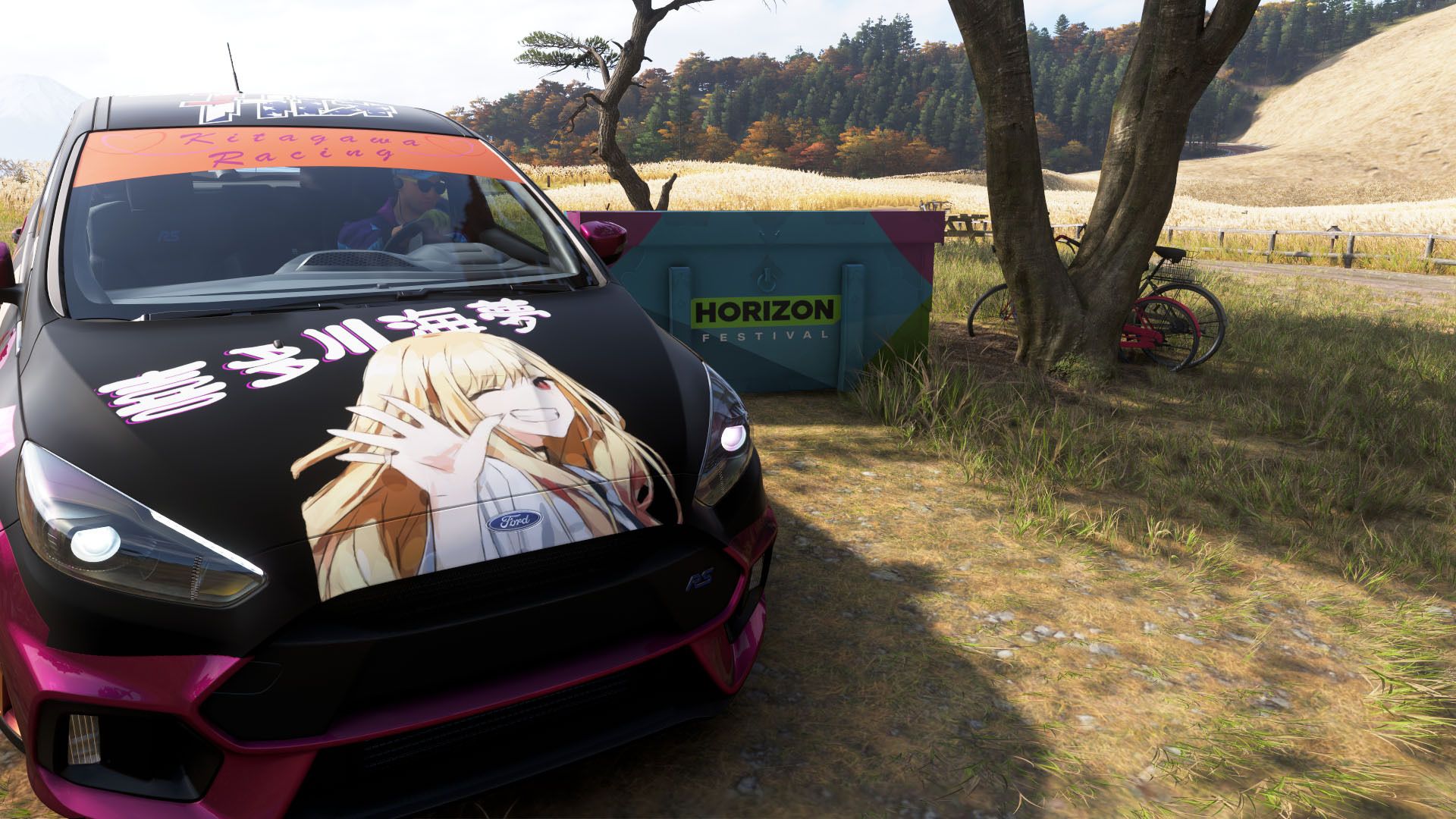 A black car with a girl on its roof beside a box in Forza Horizon 6.