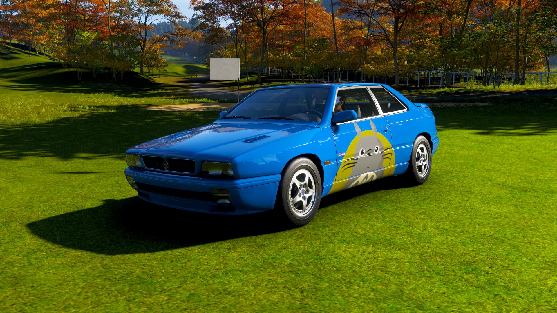 A 1997 Maserati Ghibli with a Totoro painted onto it at a golf course in Forza Horizon 6.