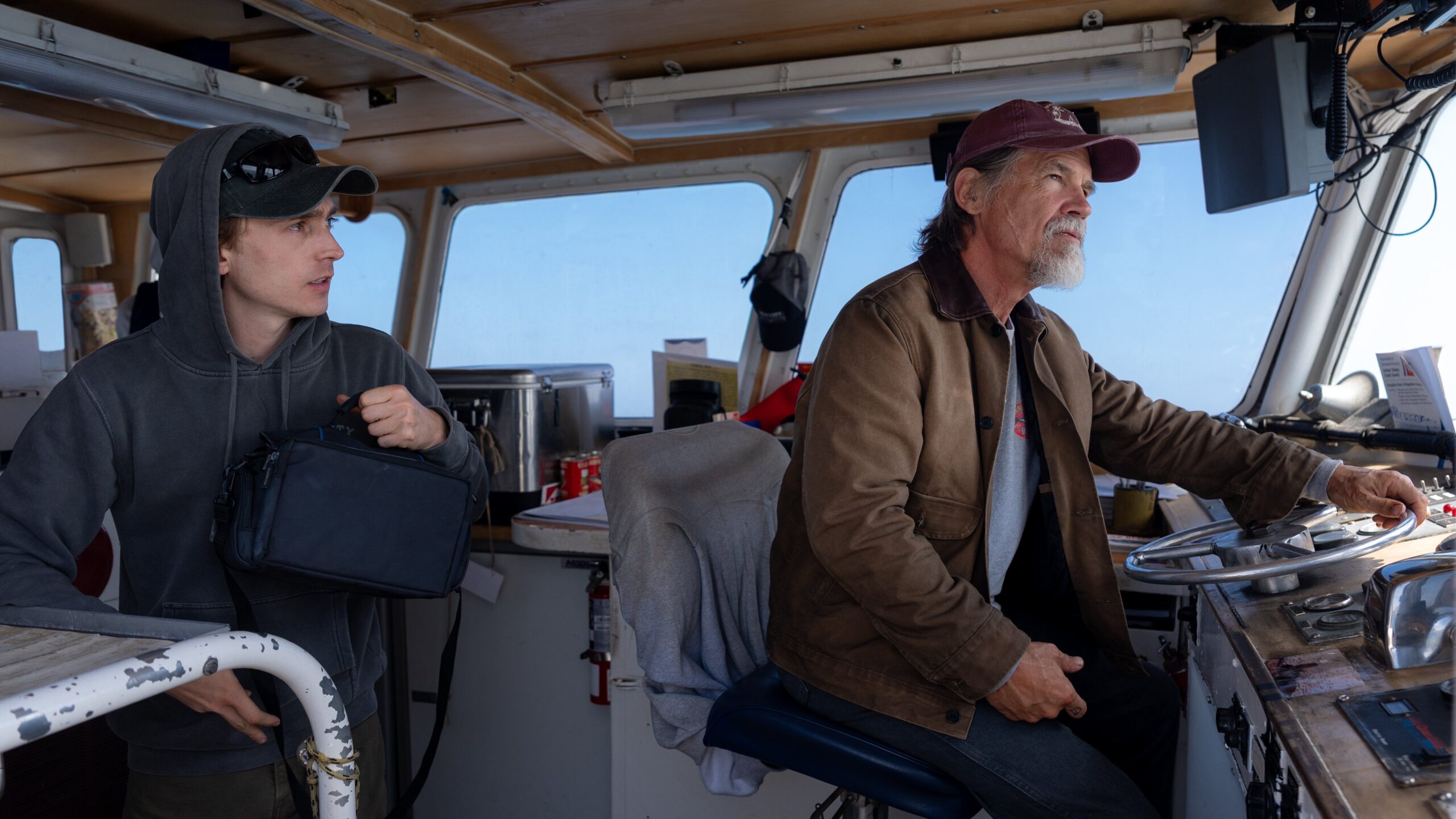 Jay (Austin Abrams) and Mitt (Josh Brolin) sit in the cockpit of a boat in Whalefall
