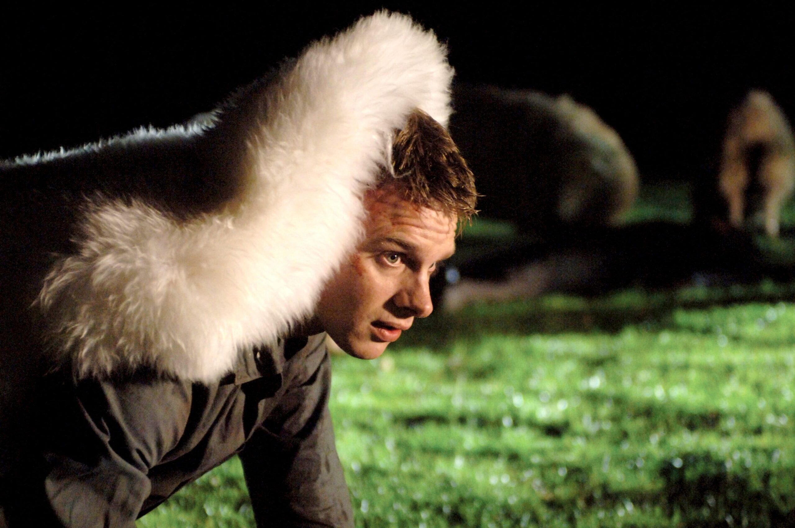 Henry, wearing a sheep rug over his head, makes his way through a field of killer sheep.