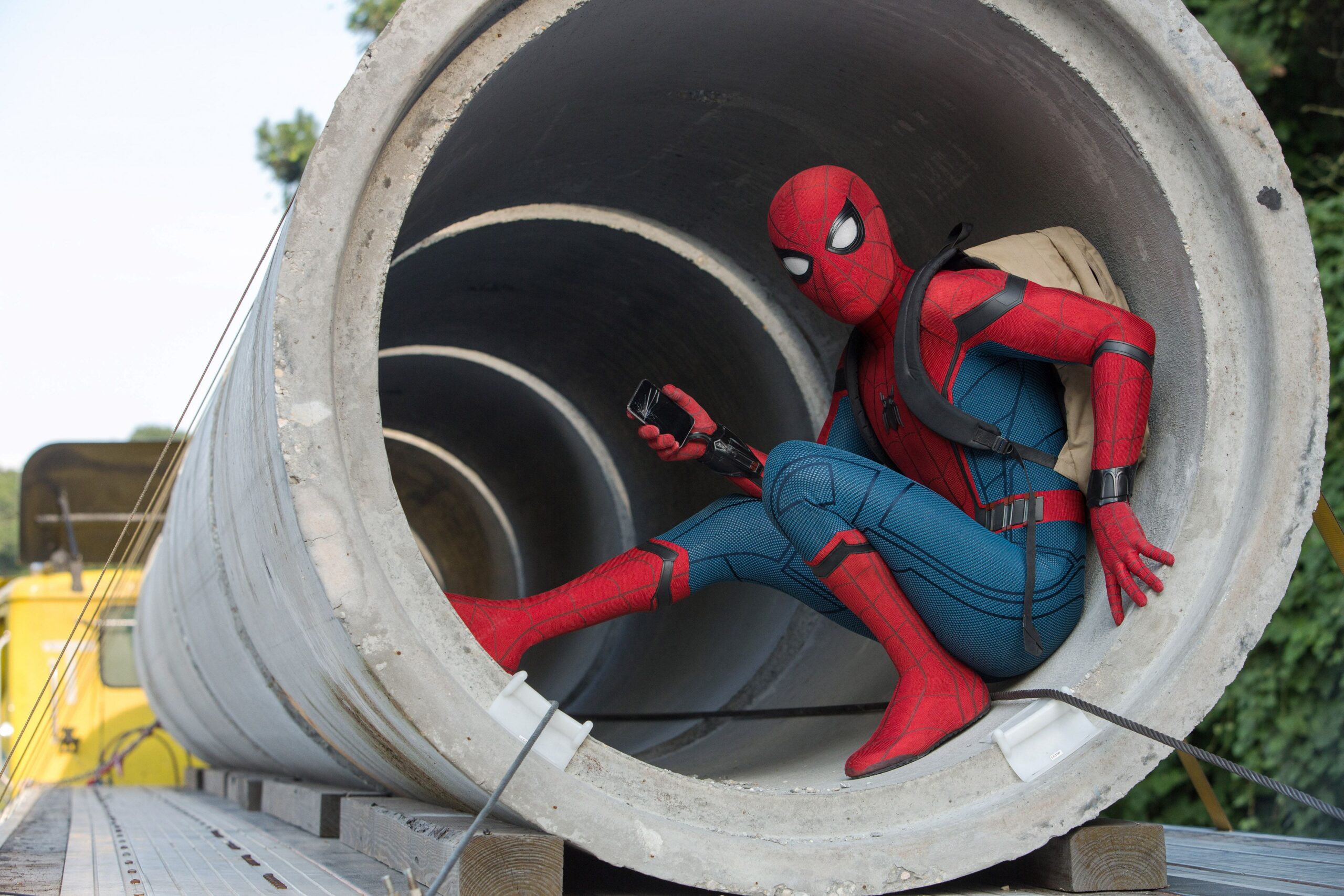 Spider-Man poses inside a concrete pipe at a construction site in Homecoming