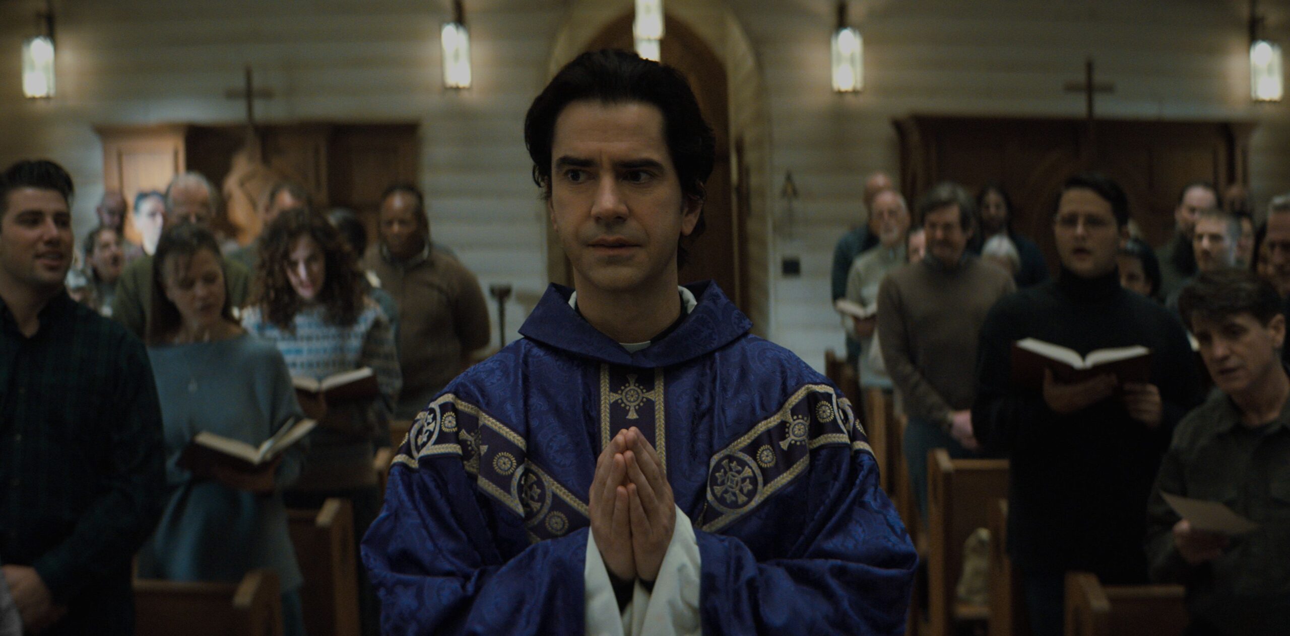 a priest in front of a church in midnight mass