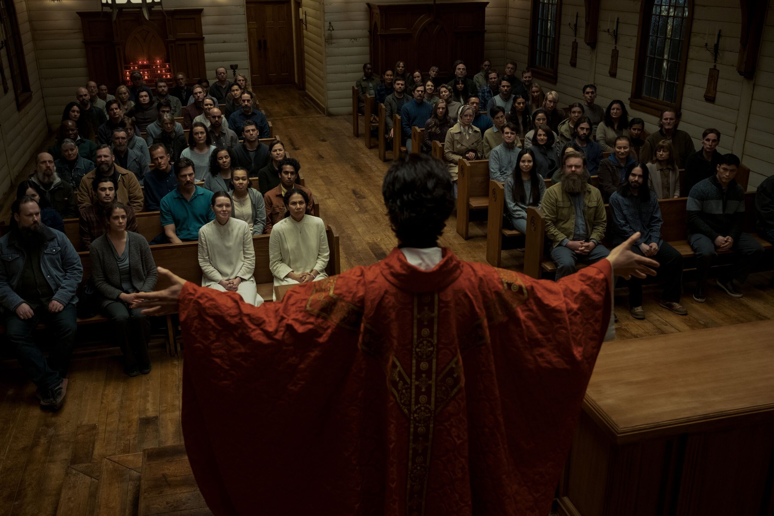 A mysterious priest leads a mass in an old wooden church in Midnight Mass