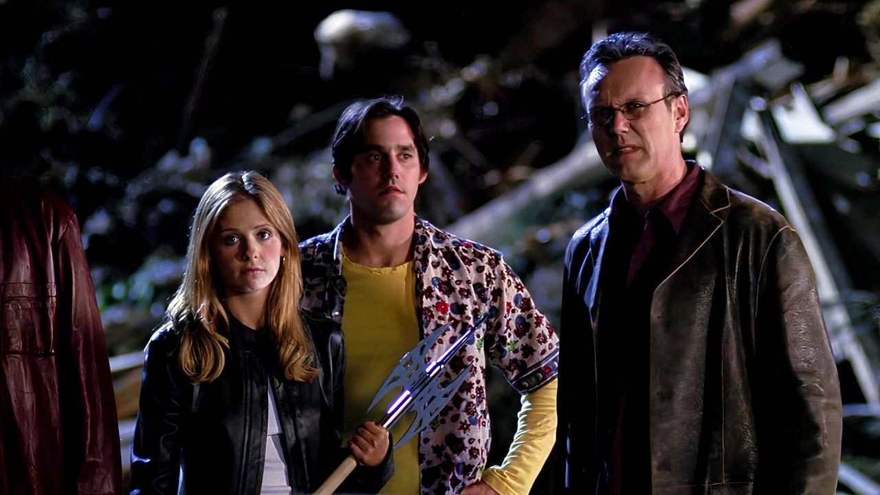 Buffy, Xander, and Giles standing in a graveyard in Buffy the Vampire Slayer
