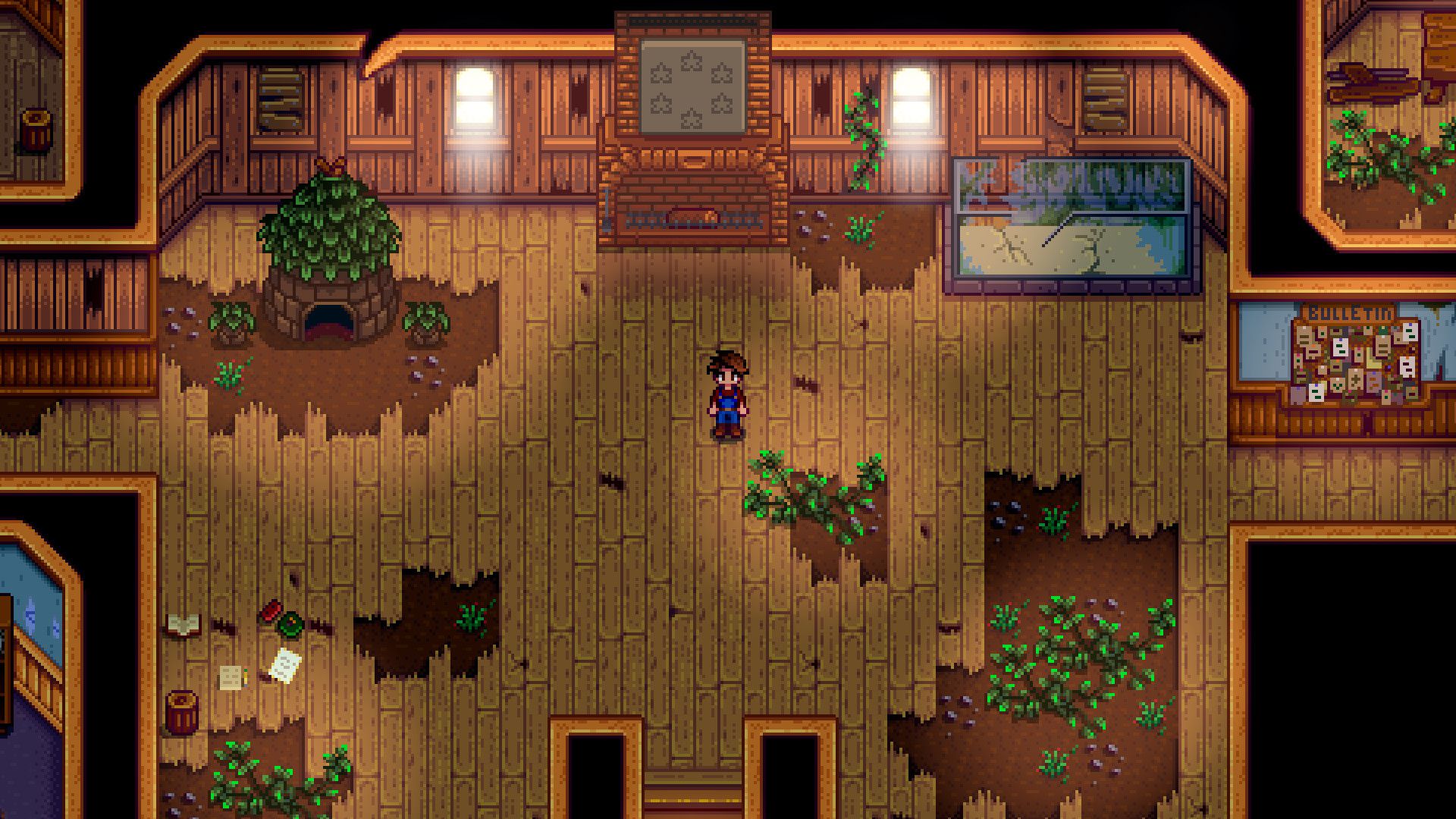 An image of a Stardew Valley character standing alone in a room. It’s a dilapidated community center.