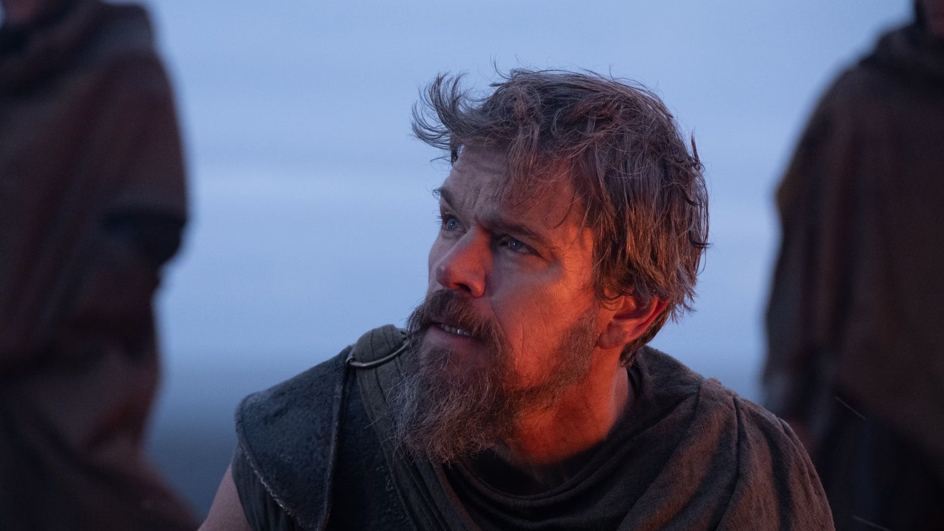 Matt Damon as Odysseus looking off screen against a blue background.